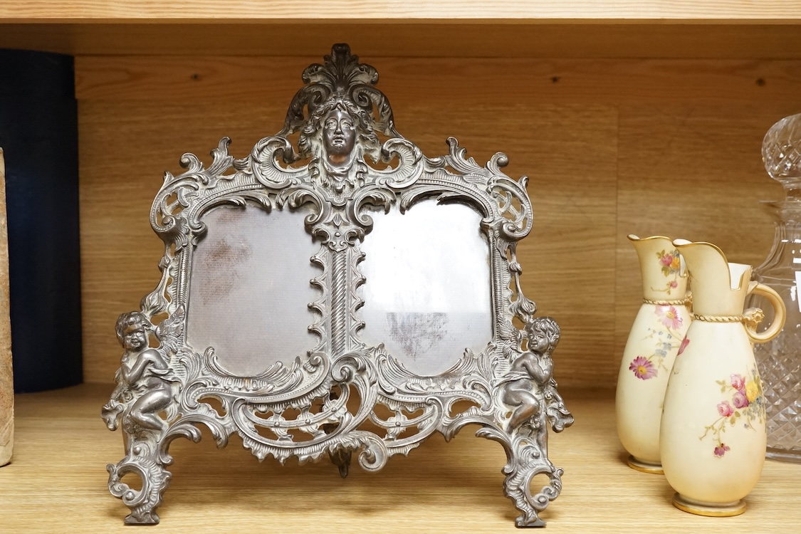 A cast brass putti double easel photo frame, 34cm high